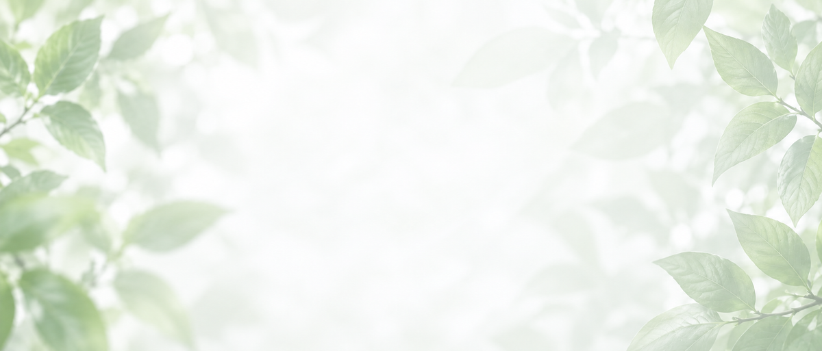A bright, airy background with soft-focus green leaves framing the edges of the image, leaving a clean white center.